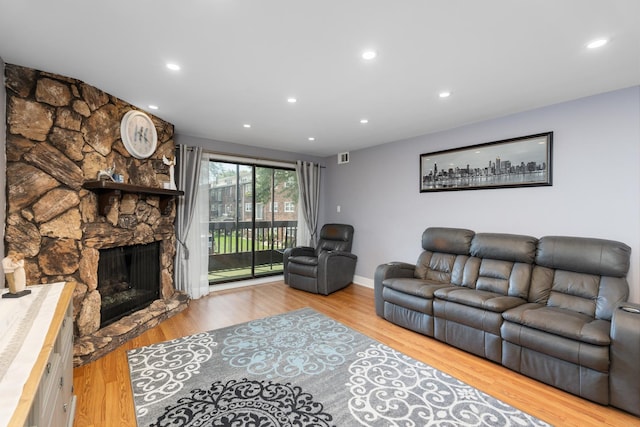 living room with a fireplace and light wood-type flooring