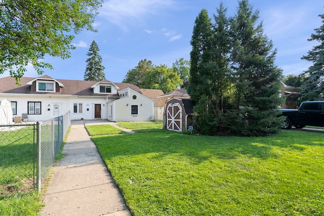 view of front facade featuring a front yard and a storage shed