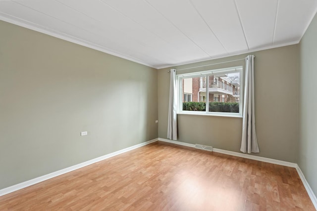 unfurnished room featuring ornamental molding and light wood-type flooring