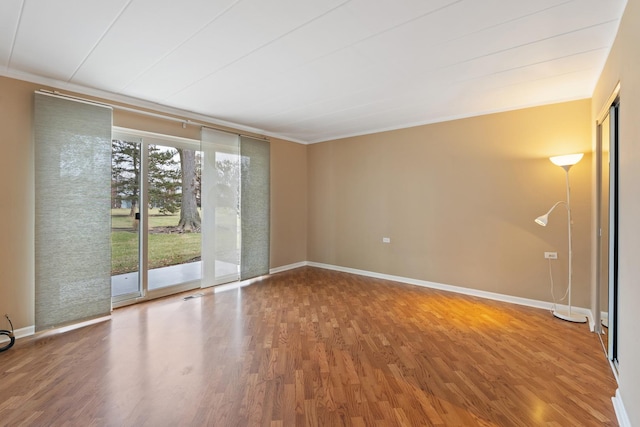 empty room with ornamental molding and hardwood / wood-style floors