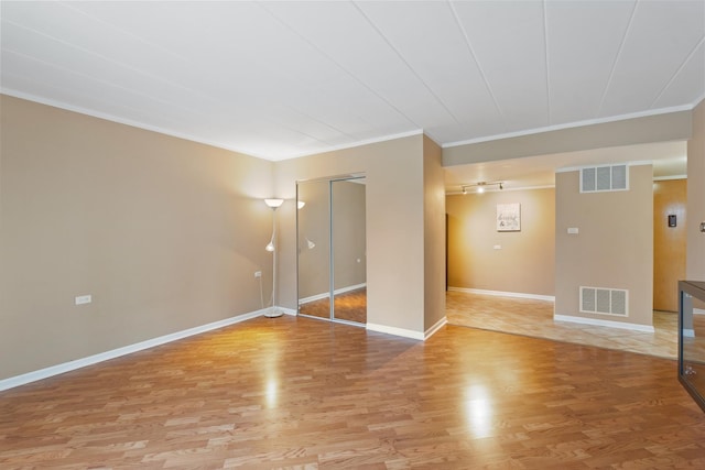 unfurnished room featuring ornamental molding and light hardwood / wood-style flooring