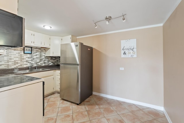 kitchen with white cabinetry, sink, stainless steel fridge, backsplash, and light tile patterned floors