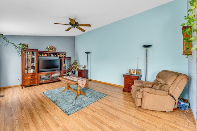 living room featuring ceiling fan, vaulted ceiling, and light wood-type flooring