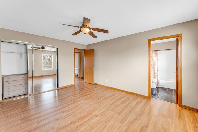 unfurnished bedroom featuring light hardwood / wood-style flooring, a closet, ceiling fan, and ensuite bathroom