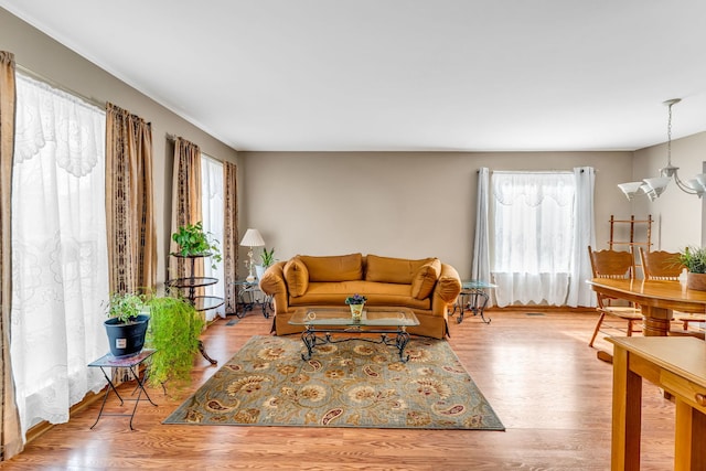 living room with light hardwood / wood-style flooring and a notable chandelier