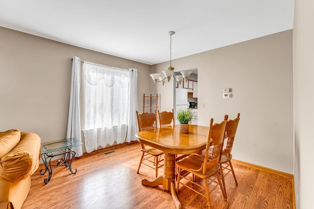 dining room featuring light hardwood / wood-style flooring and a chandelier