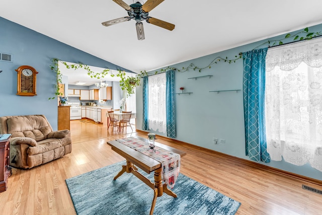 living room featuring lofted ceiling, light hardwood / wood-style floors, and ceiling fan