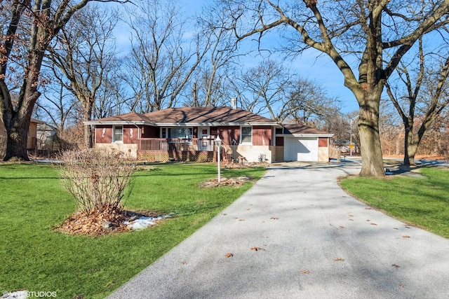 ranch-style home with a garage, a front yard, and covered porch