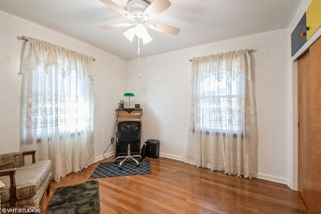 sitting room with ceiling fan, wood-type flooring, and plenty of natural light