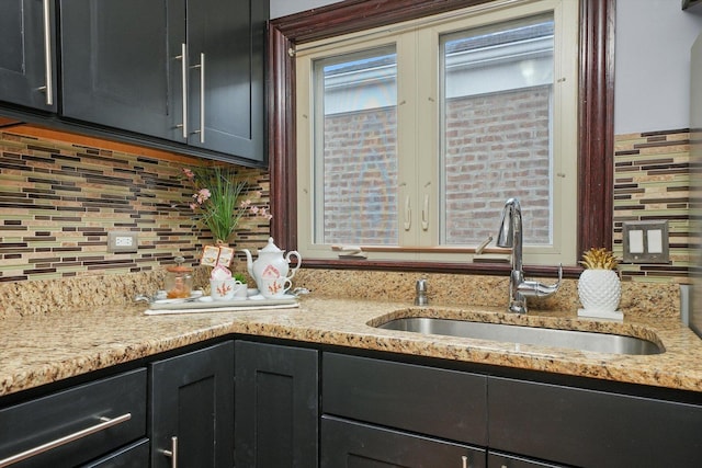 kitchen featuring light stone countertops, sink, and decorative backsplash