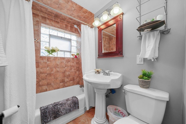 bathroom with tile patterned flooring, shower / bath combo, and toilet