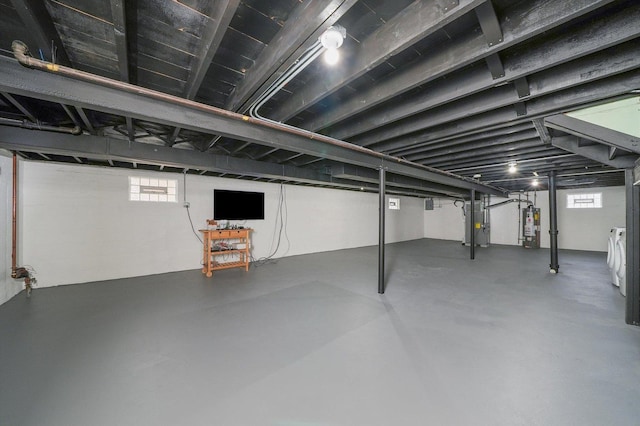 basement with water heater and washer and dryer