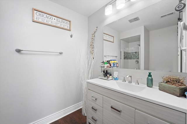 bathroom with vanity, hardwood / wood-style floors, and a shower with door