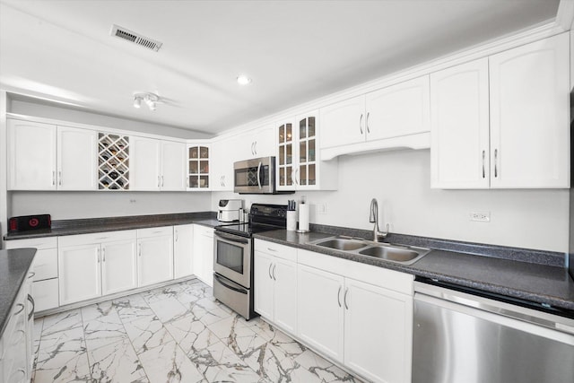 kitchen with appliances with stainless steel finishes, sink, and white cabinets