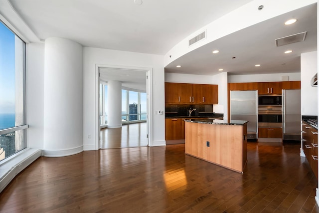 kitchen featuring tasteful backsplash, stainless steel appliances, dark hardwood / wood-style flooring, and a kitchen island