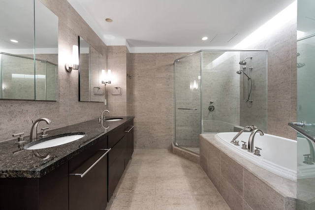 bathroom featuring vanity, independent shower and bath, tile patterned flooring, and tile walls