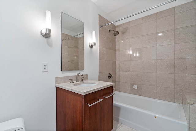 full bathroom featuring tiled shower / bath, vanity, and toilet