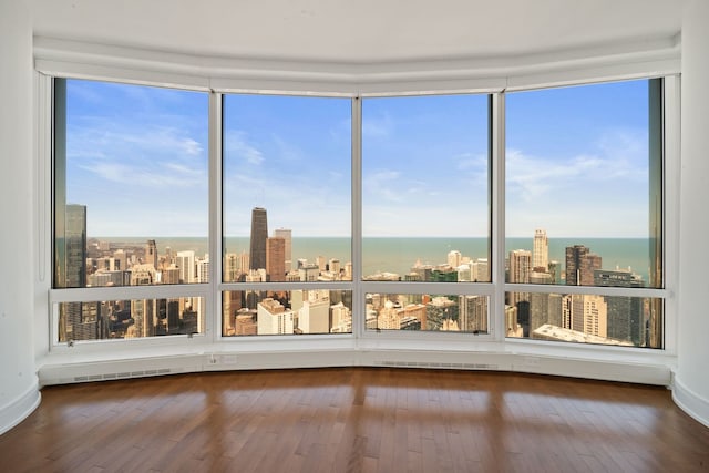 unfurnished sunroom featuring plenty of natural light, a water view, a view of city, and visible vents
