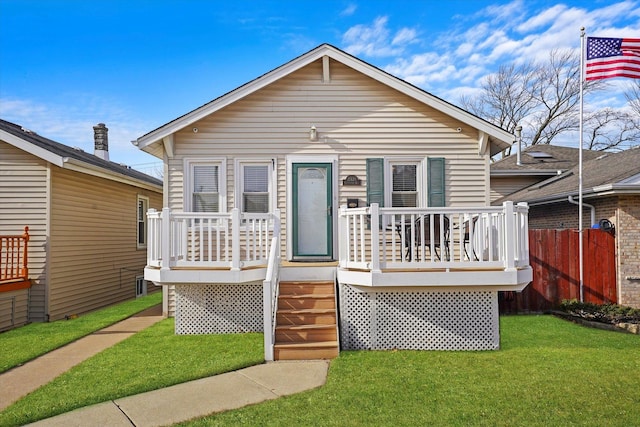 bungalow with a front lawn and a deck