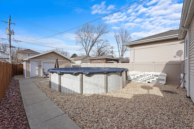 view of yard featuring a garage, an outdoor structure, and a covered pool