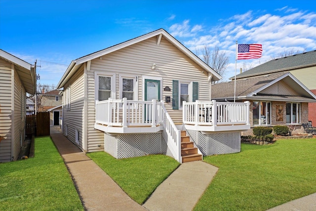 bungalow featuring a wooden deck and a front lawn