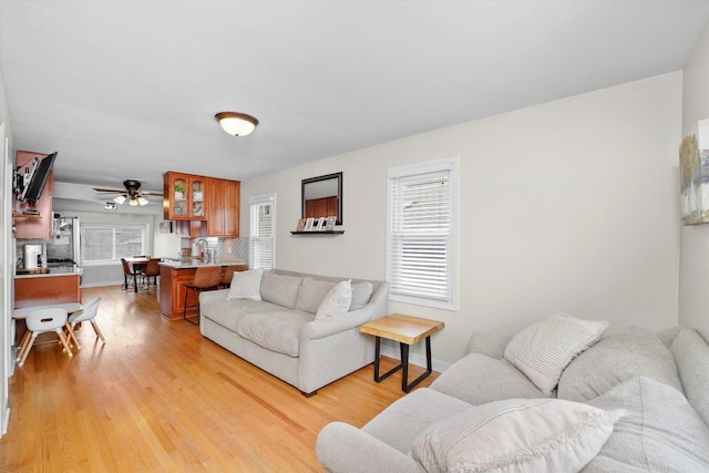 living room with ceiling fan and light wood-type flooring