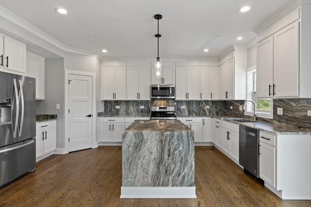 kitchen with pendant lighting, sink, white cabinets, a center island, and stainless steel appliances