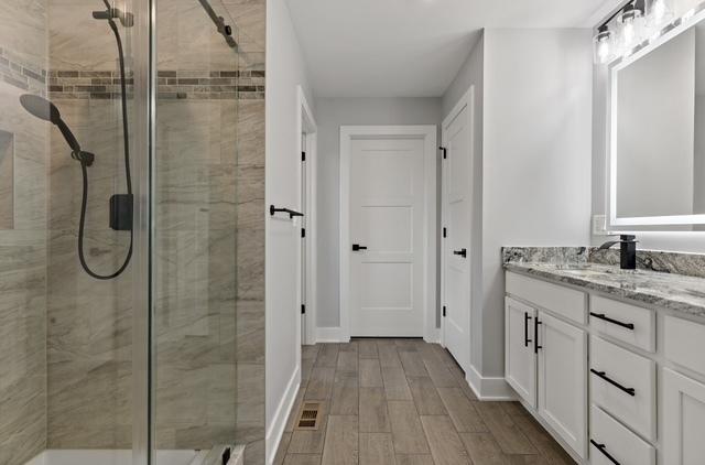 bathroom featuring vanity, an enclosed shower, and hardwood / wood-style floors