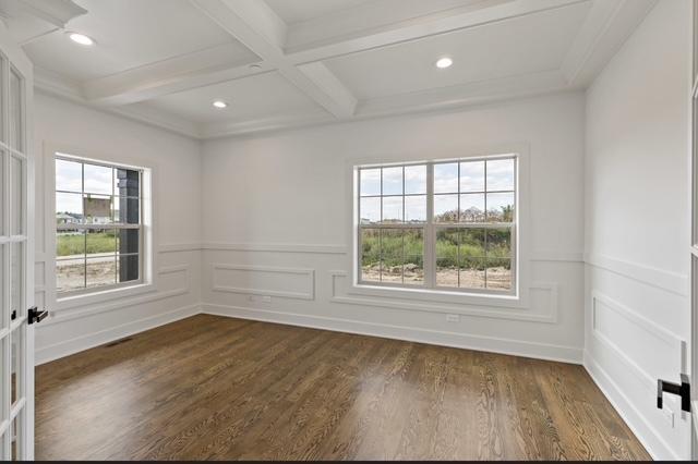 spare room with beamed ceiling, coffered ceiling, dark wood-type flooring, and french doors