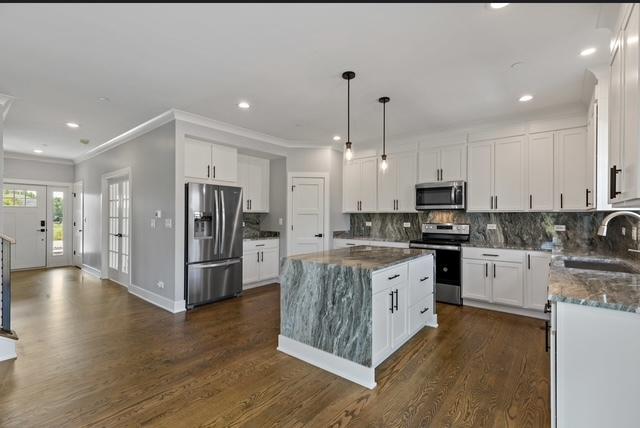 kitchen featuring a kitchen island, white cabinetry, appliances with stainless steel finishes, and sink