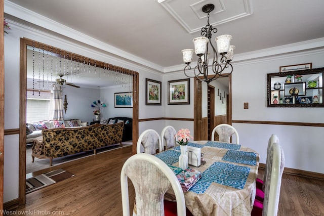 dining area featuring crown molding, dark hardwood / wood-style floors, and a chandelier