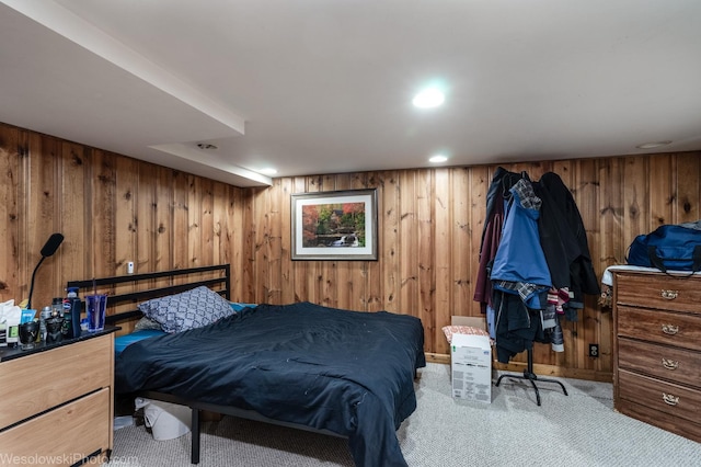 carpeted bedroom featuring wooden walls