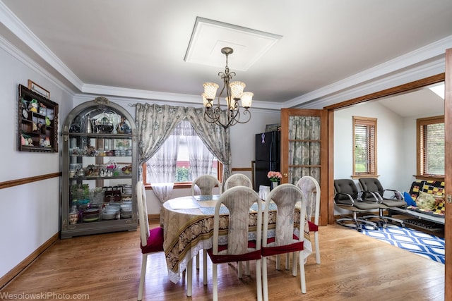 dining area featuring a notable chandelier, crown molding, a wealth of natural light, and wood-type flooring