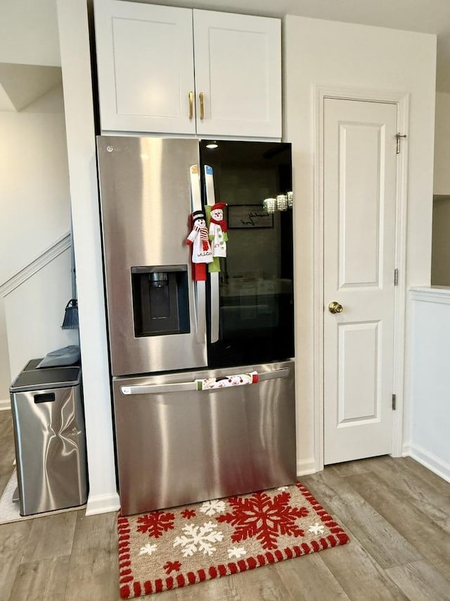 kitchen featuring stainless steel refrigerator with ice dispenser, white cabinetry, and light hardwood / wood-style floors