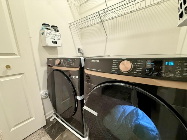 washroom featuring washer and clothes dryer and dark tile patterned flooring