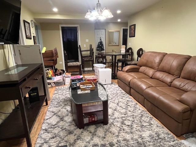 living room featuring a chandelier and light wood-type flooring