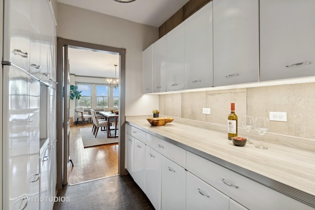 interior space with a notable chandelier and white cabinets