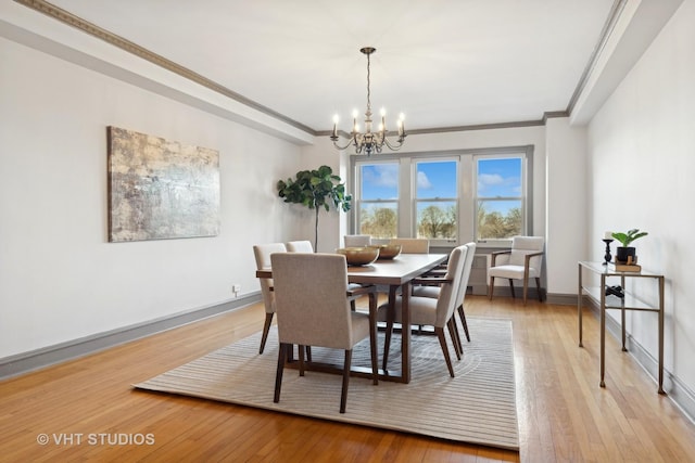 dining area featuring ornamental molding, a chandelier, and light hardwood / wood-style flooring