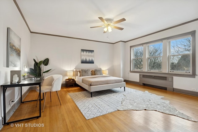 bedroom with crown molding, radiator heating unit, and light wood-type flooring