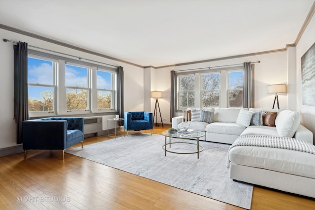 living room with hardwood / wood-style flooring, crown molding, and plenty of natural light