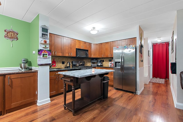 kitchen with dark hardwood / wood-style floors, sink, a center island, range, and stainless steel fridge with ice dispenser