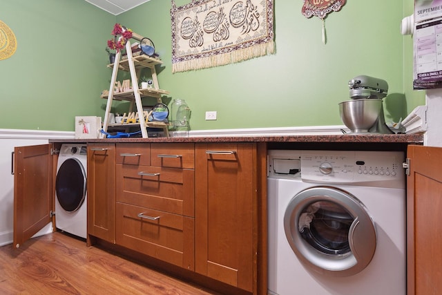 washroom featuring cabinets, wood-type flooring, and washer / dryer