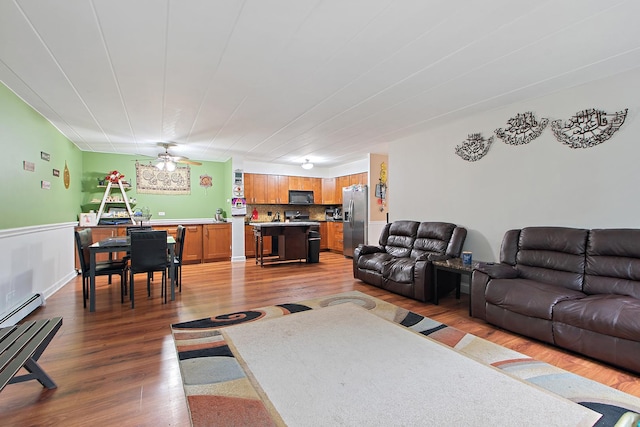 living room featuring ceiling fan, wood-type flooring, and a baseboard radiator