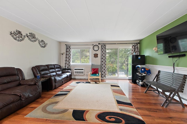 living room with hardwood / wood-style floors and an AC wall unit