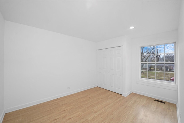 unfurnished bedroom with light hardwood / wood-style floors and a closet