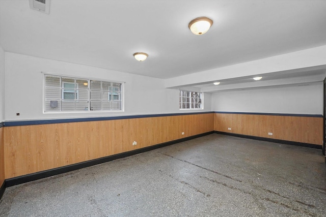 unfurnished room featuring wood walls