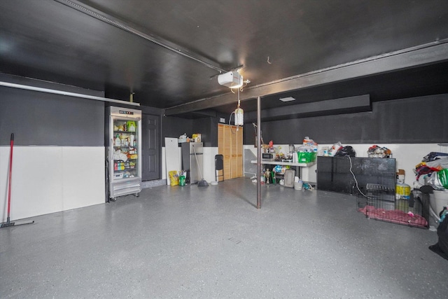 garage featuring a garage door opener and stainless steel fridge