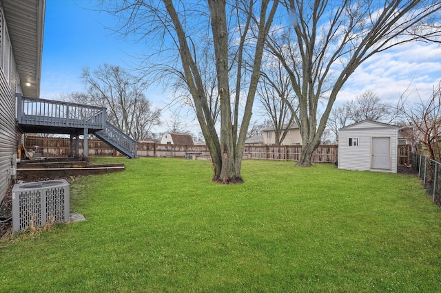 view of yard featuring central AC, a deck, and a shed