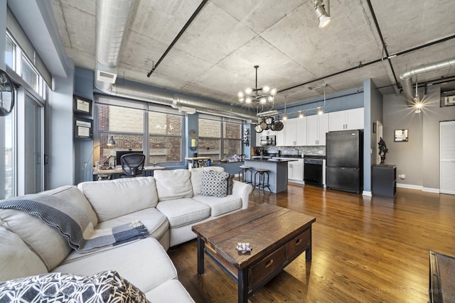 living room featuring an inviting chandelier and dark hardwood / wood-style floors