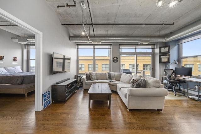 living room with plenty of natural light and dark wood-type flooring